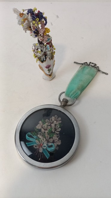 Medalhão e jarra com arranjos florais 