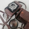 Três máquinas fotográficas e lente 