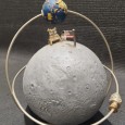Expositor de relógio Ómega alusivo ao 50° Aniversário da missão Apollo11 à Lua e ao relógio Omega Speedmaster que acompanhou a tripulação de astronautas